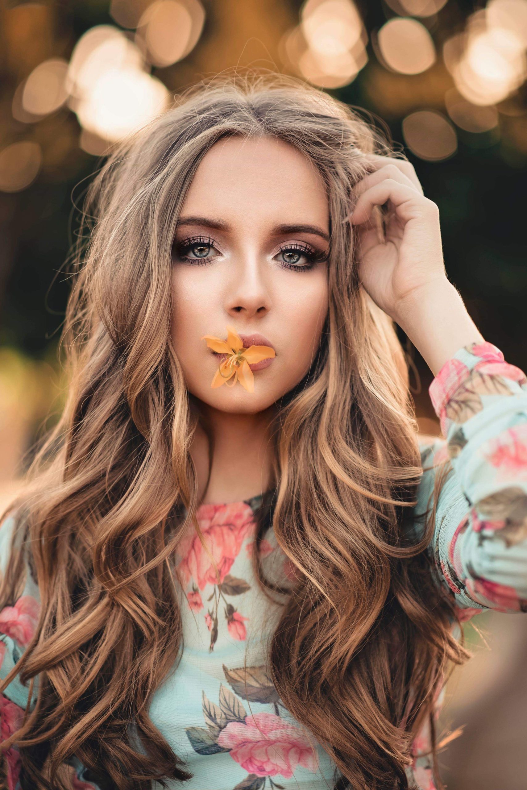 woman-with-orange-petaled-flower-on-her-lips-1937394